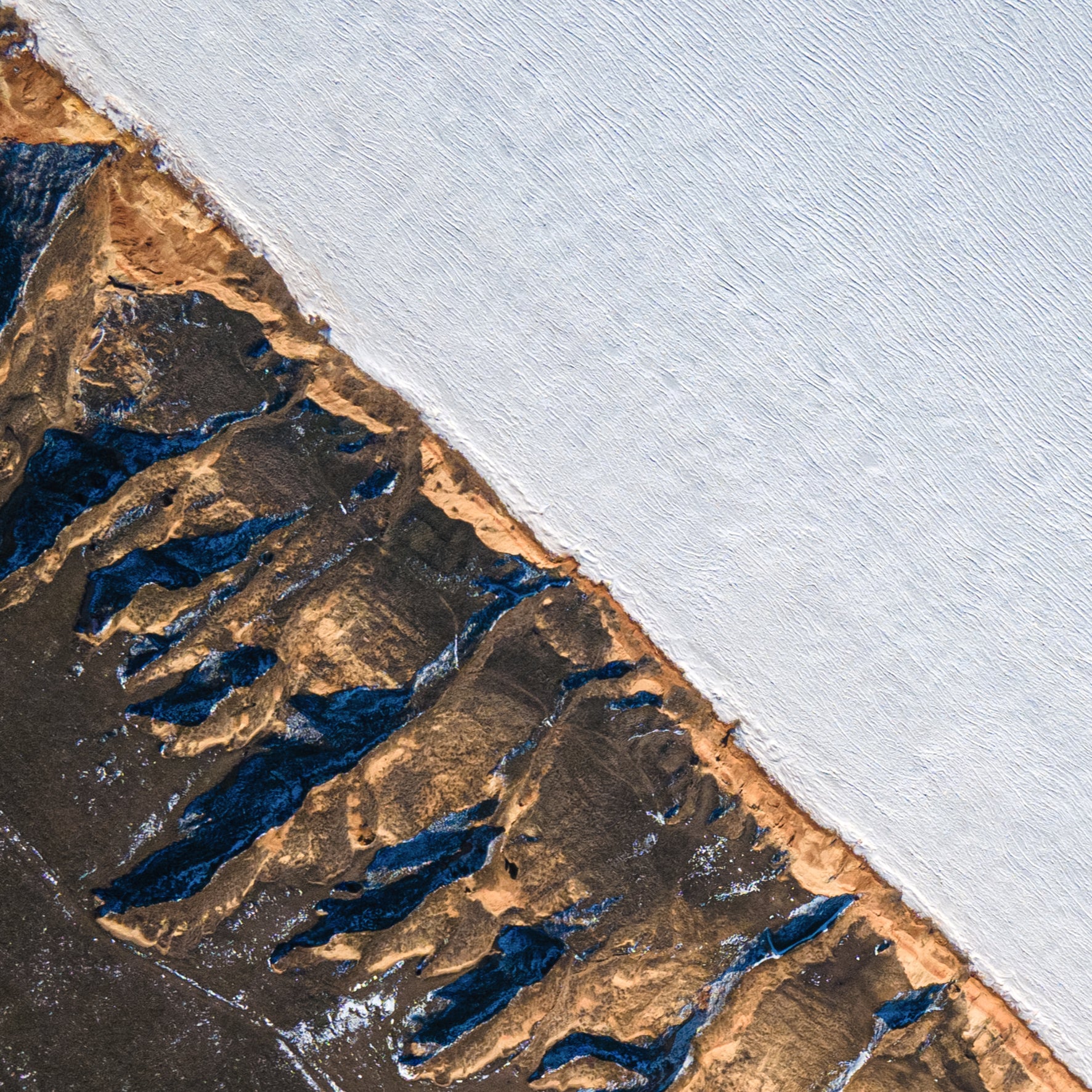Aerial view of a river cutting through a landscape with contrasting colors.