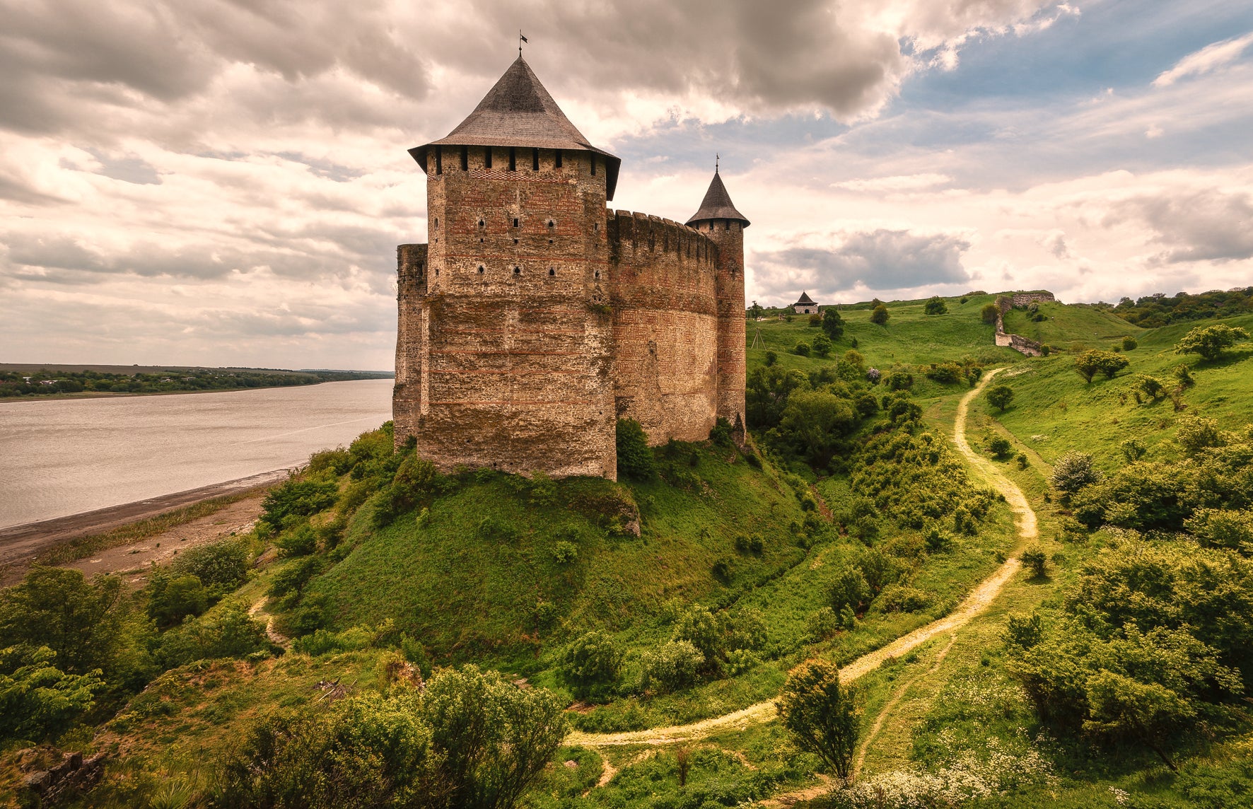 Medieval castle on a hill with a river in the background