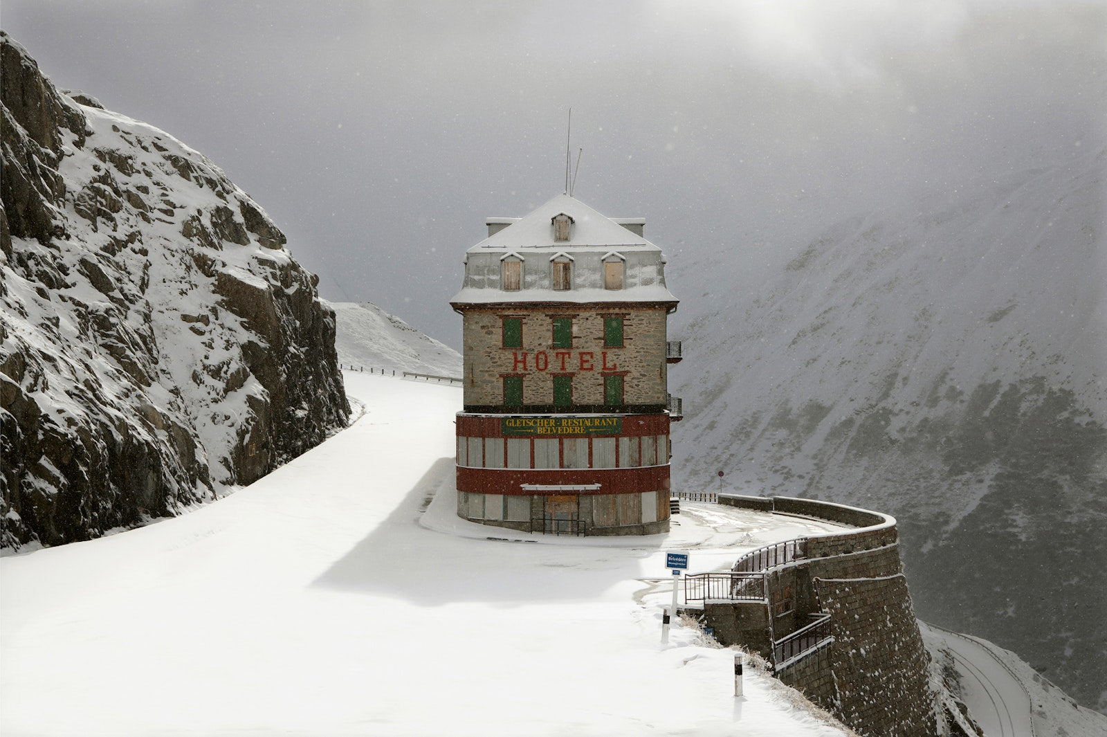 Snow-covered mountain landscape with an old-style hotel sign.