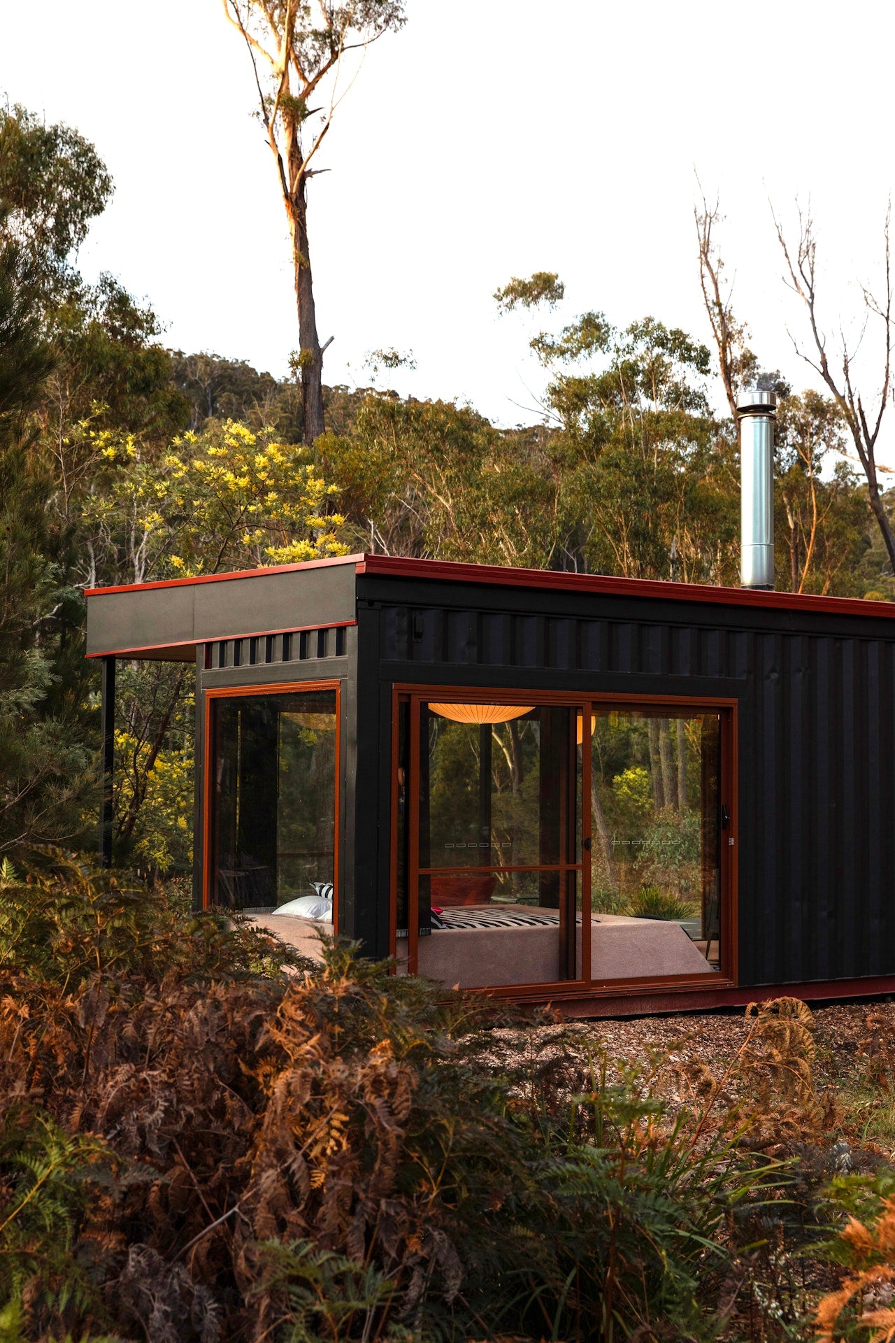 Small cabin made from shipping containers in a forest setting