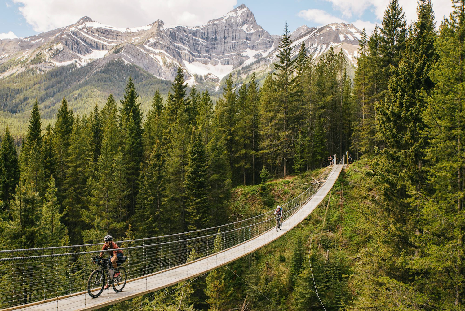 Deux cyclistes sur un pont dans les montagnes en bikepacking.