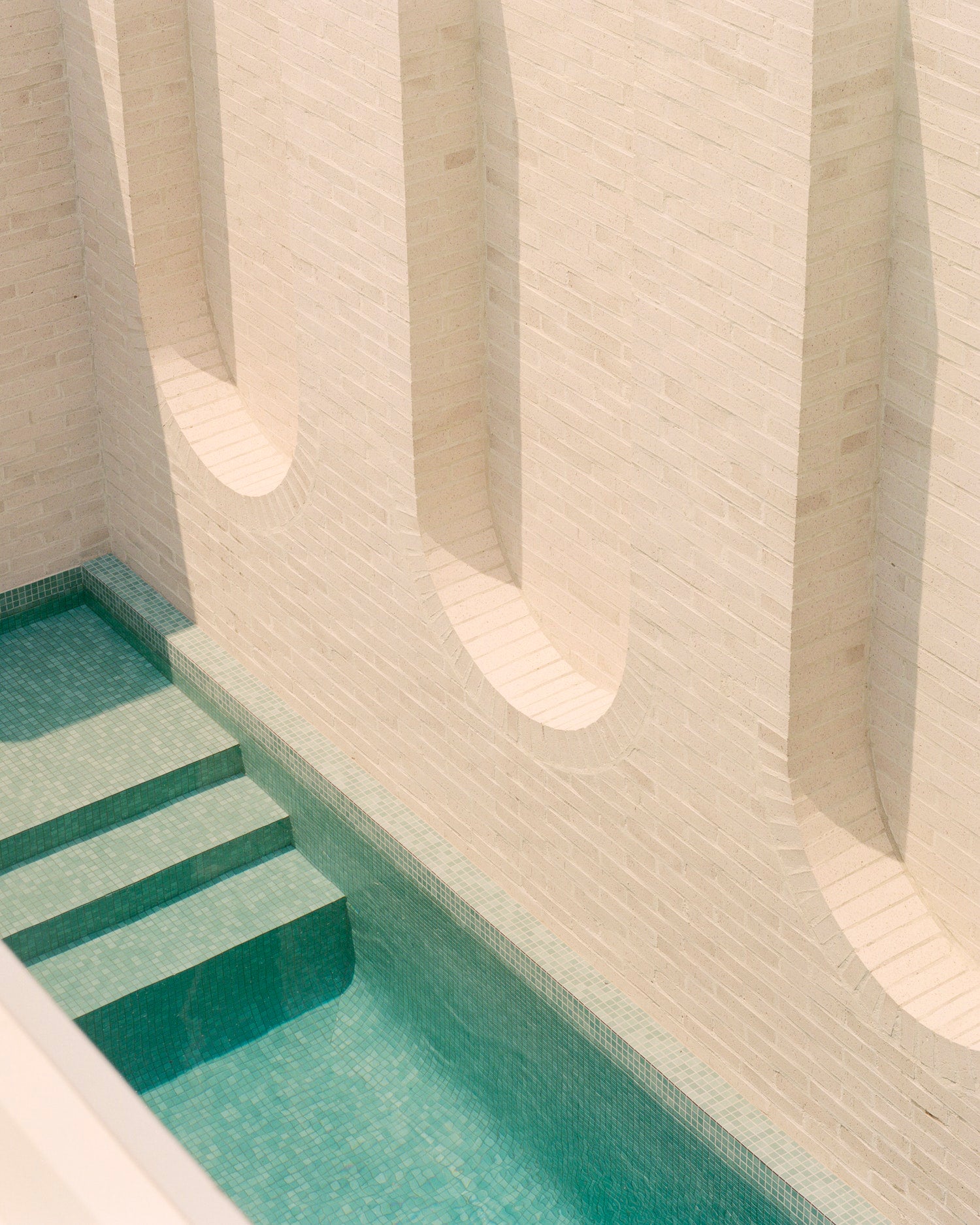 This beautiful pool is part of an inspiring family home with a contemporary aesthetic. The Ruckers Hill House was designed by Studio Bright and is featured in Brick By Brick by gestalten.