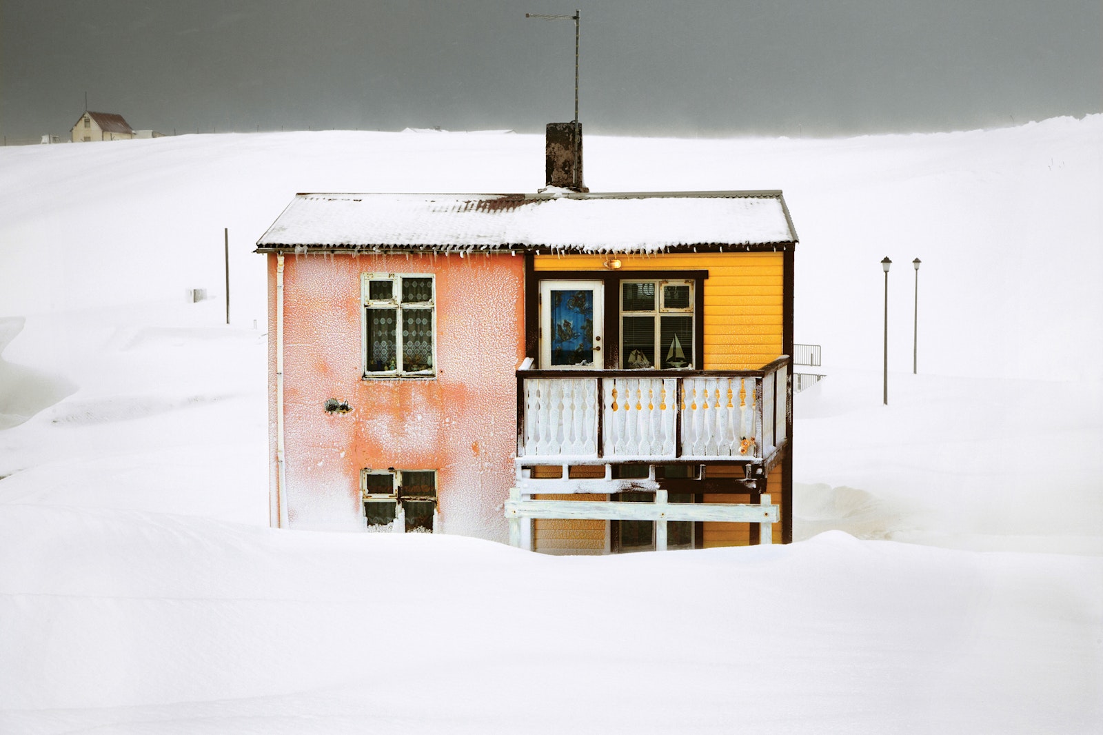 Small house with a colorful facade surrounded by snow