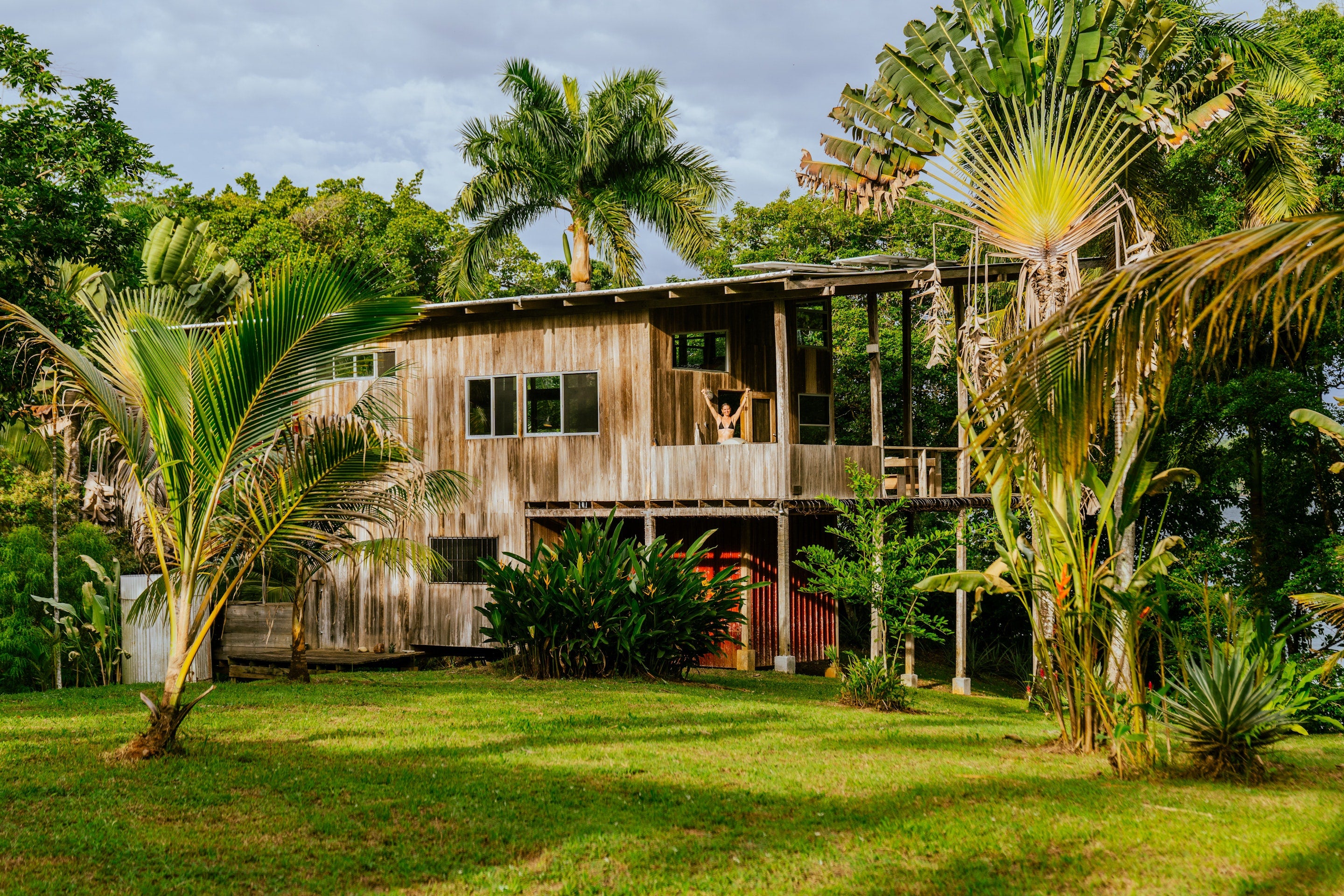 Wooden house surrounded by tropical plants and trees