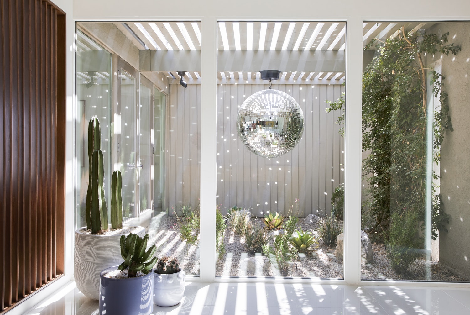 Until they found this home from 1957, the residents were planning to build a custom house from scratch. The dining chairs seen above are from ModShop, and the fringed lighting is from Manfredi Style. The disco ball hanging over the cactus garden was installed at the request of the residents’ daughter. Learn more about the history of Marrow Midcentury by Bells + Whistles in House of Joy.