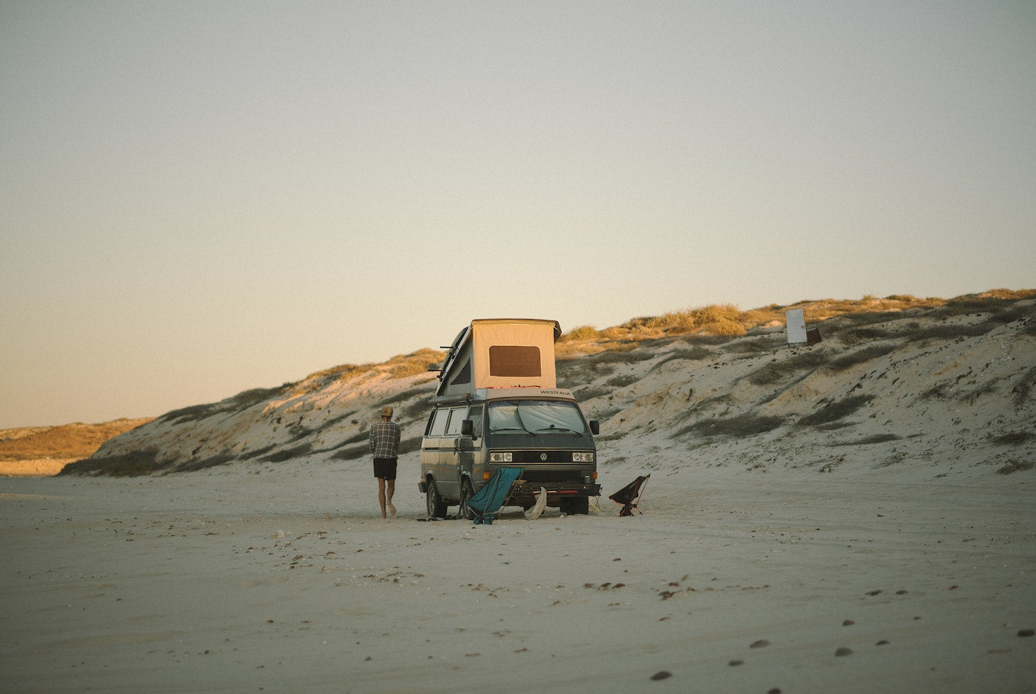 Un Van Westfalia sur une plage, présenté dans La vie nomade, un livre publié par gestalten.